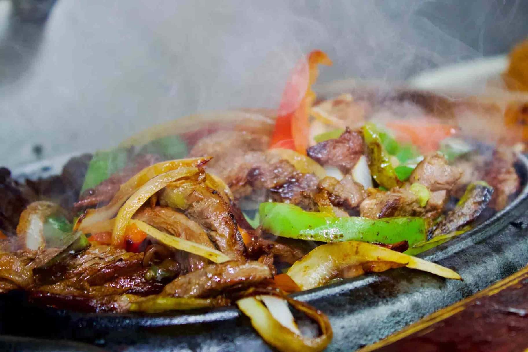 Sizzling fajitas skillet with peppers and onions