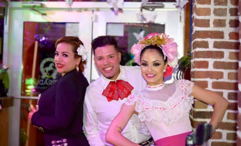 Mariachi and dance entertainers posing together at the restaurant