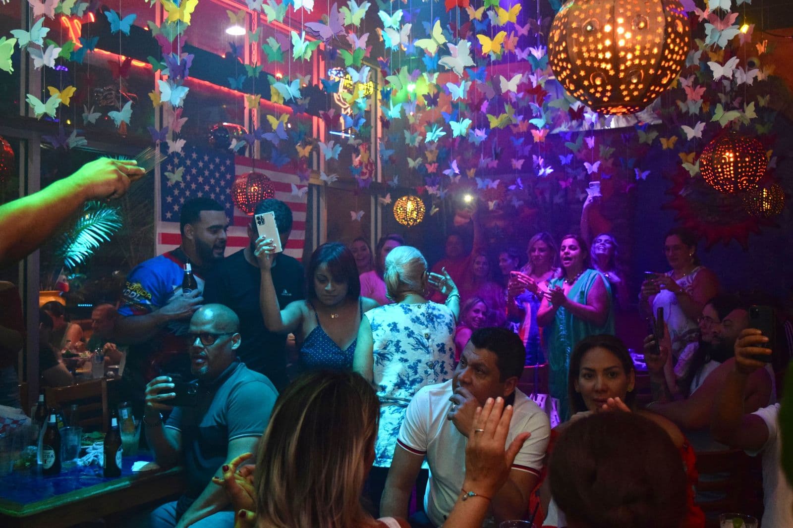 Crowd dancing under butterfly decorations at a La Herradura fiesta