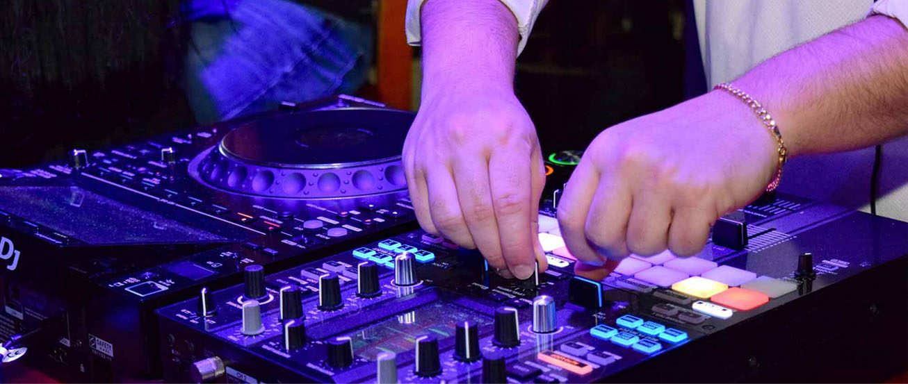 DJ Oteo mixing on turntables under purple lights